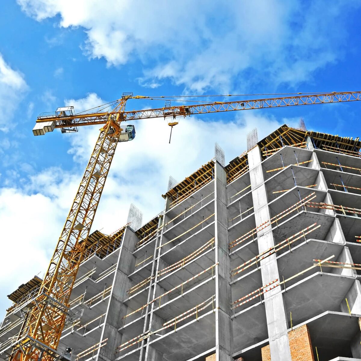 Crane And Building Construction Site Against Blue Sky